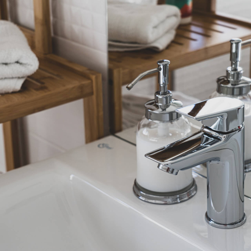 stainless-steel-faucet-on-white-ceramic-sink-3761560